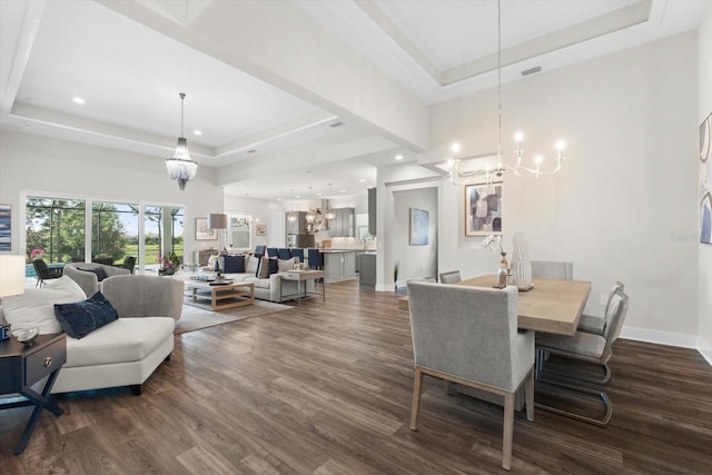 dining space featuring a notable chandelier, dark hardwood / wood-style floors, and a raised ceiling