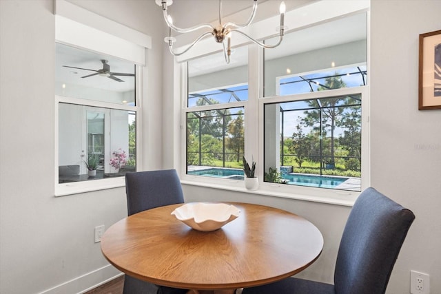 dining area featuring ceiling fan with notable chandelier and wood-type flooring