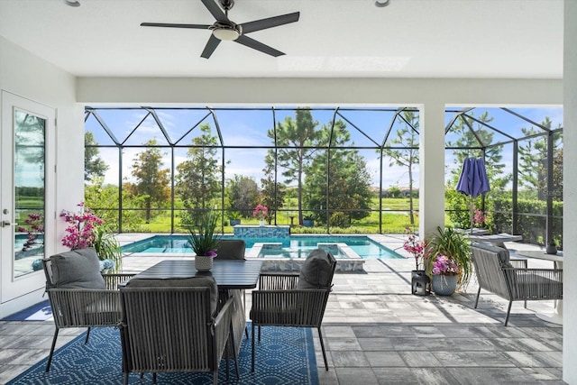 view of patio / terrace featuring a swimming pool with hot tub, glass enclosure, and ceiling fan