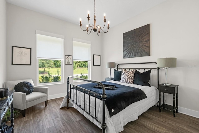 bedroom with a chandelier and dark wood-type flooring