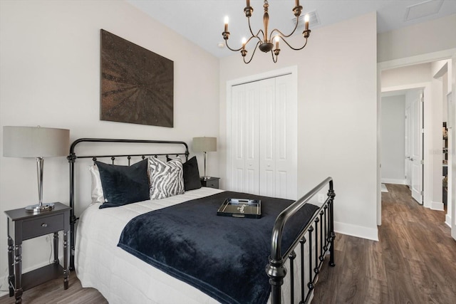 bedroom with dark hardwood / wood-style flooring, a closet, and a notable chandelier