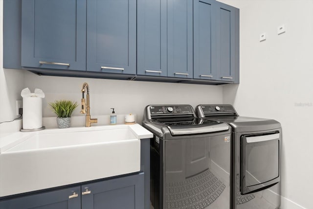 clothes washing area with washing machine and clothes dryer, sink, and cabinets