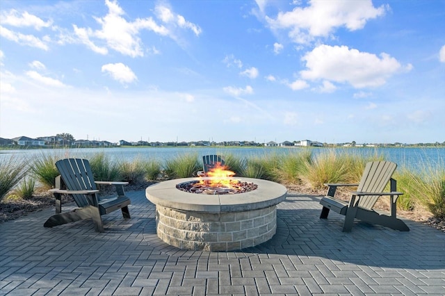 view of patio with a water view and an outdoor fire pit