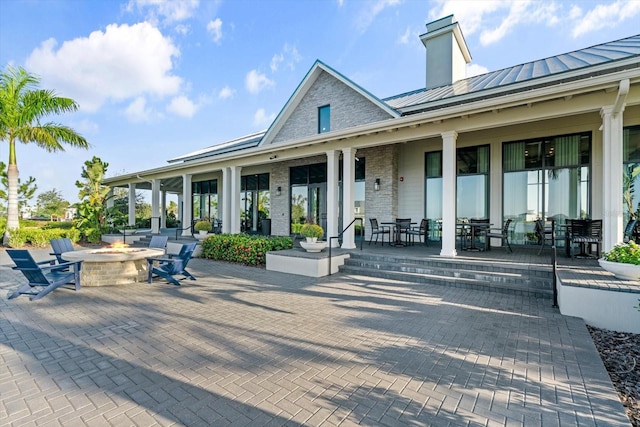 rear view of house with a patio and a fire pit