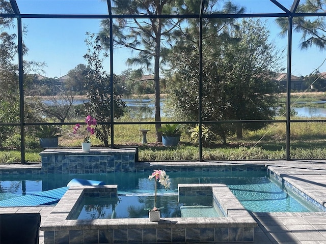 view of pool featuring glass enclosure, a water view, and an in ground hot tub