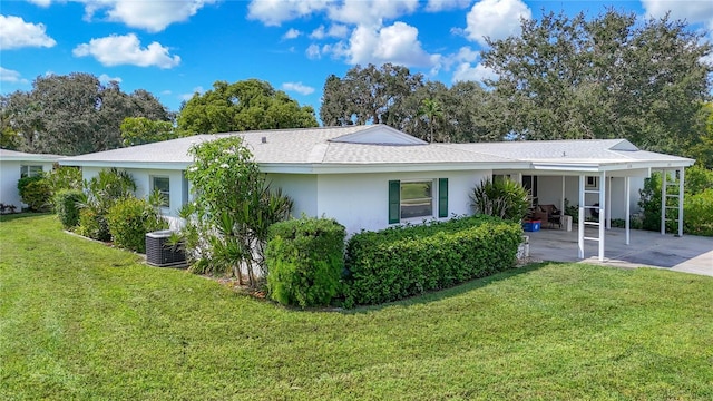 back of house with central AC unit, a lawn, and a carport