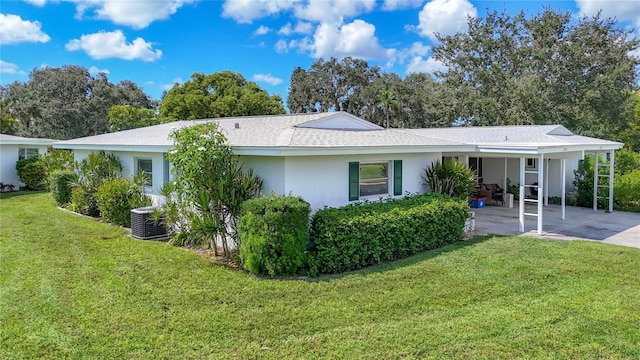 back of house with stucco siding, central AC, concrete driveway, and a lawn