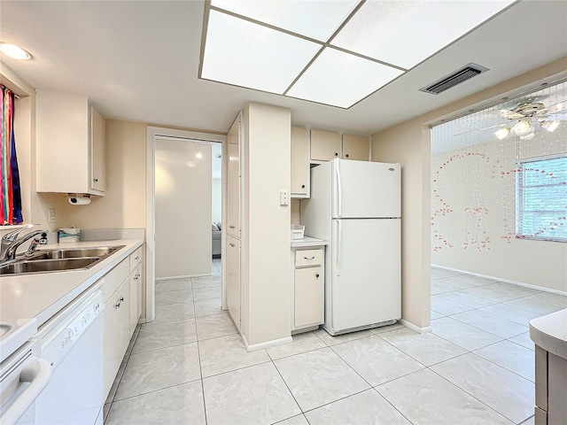 kitchen featuring light tile patterned floors, white cabinets, sink, and white appliances