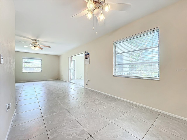 spare room with baseboards, a ceiling fan, and light tile patterned floors