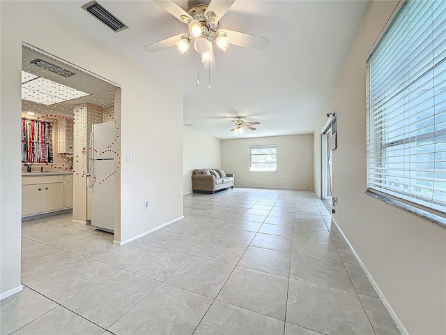 spare room with light tile patterned flooring, visible vents, and ceiling fan