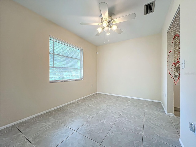 unfurnished room featuring visible vents, a ceiling fan, baseboards, and light tile patterned floors