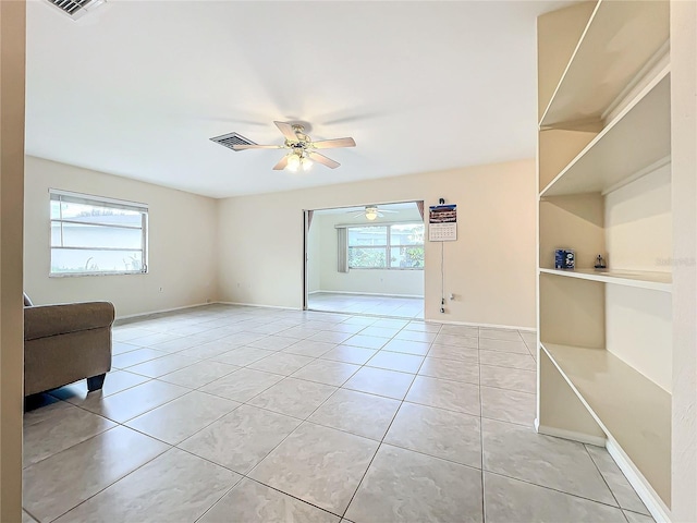 unfurnished room featuring baseboards, a ceiling fan, visible vents, and light tile patterned floors