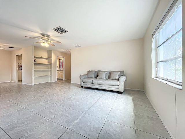 living area with visible vents, ceiling fan, and light tile patterned floors