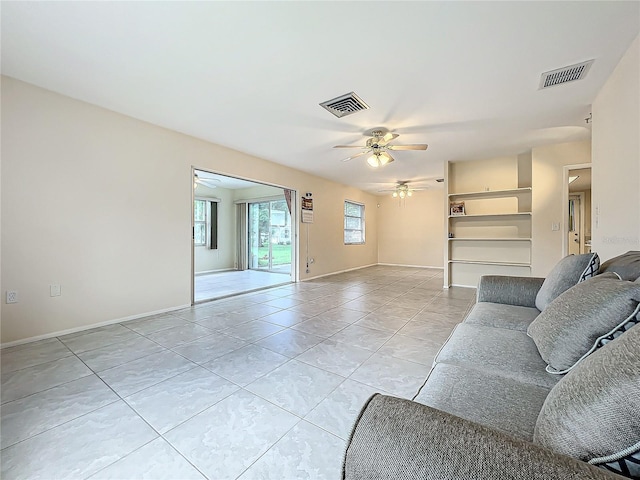 living room with light tile patterned floors, baseboards, visible vents, and ceiling fan
