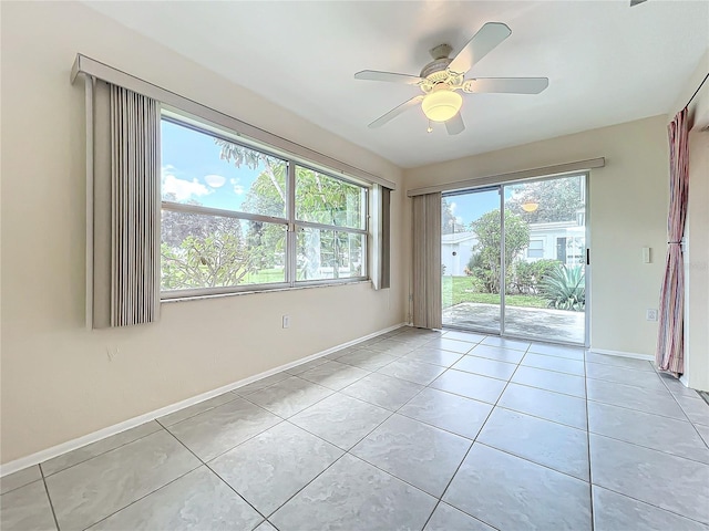 spare room featuring ceiling fan, light tile patterned floors, and a healthy amount of sunlight