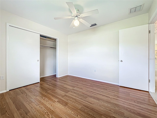 unfurnished bedroom featuring a closet, hardwood / wood-style floors, and ceiling fan