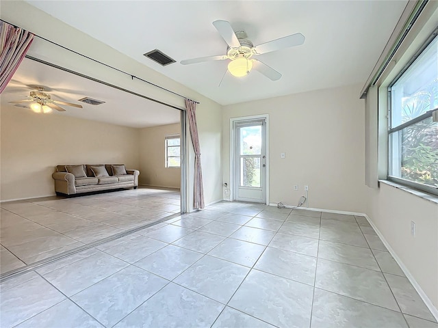 living room featuring visible vents, baseboards, ceiling fan, and light tile patterned floors