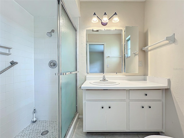 bathroom featuring a shower stall, vanity, and tile patterned floors