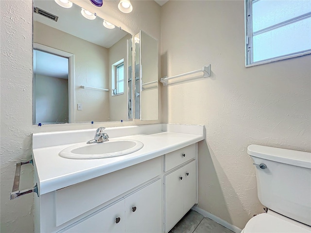 bathroom featuring vanity, tile patterned flooring, and toilet