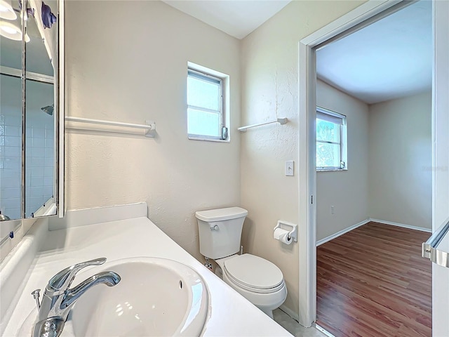 bathroom featuring wood finished floors, vanity, toilet, and baseboards