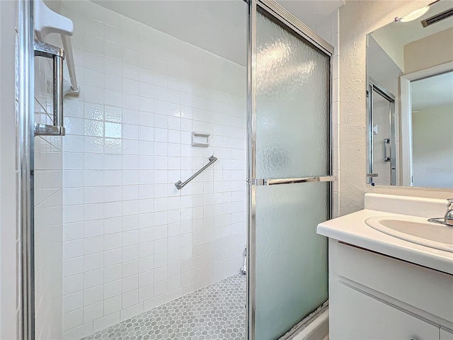full bathroom with vanity, visible vents, and a shower stall