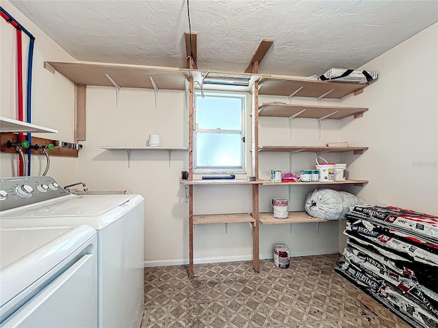 laundry room with washer and clothes dryer, a textured ceiling, light floors, baseboards, and laundry area