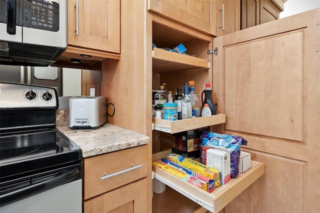 kitchen with light stone countertops, stainless steel electric range oven, and light brown cabinetry