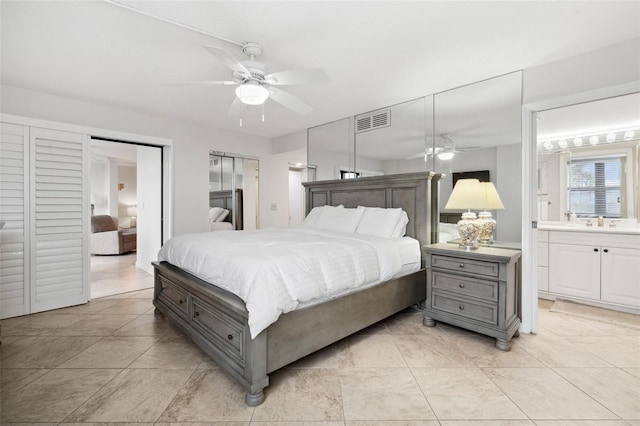 bedroom featuring ensuite bath, a sink, visible vents, and a ceiling fan