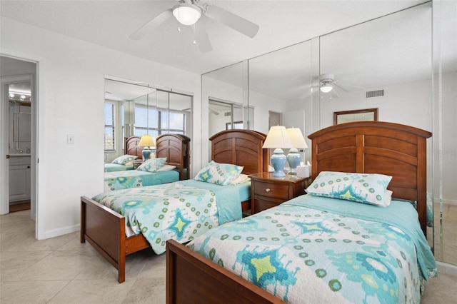 bedroom with light tile patterned floors, a closet, visible vents, a ceiling fan, and baseboards