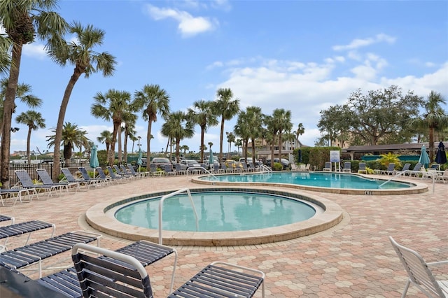 community pool featuring a patio area and a hot tub