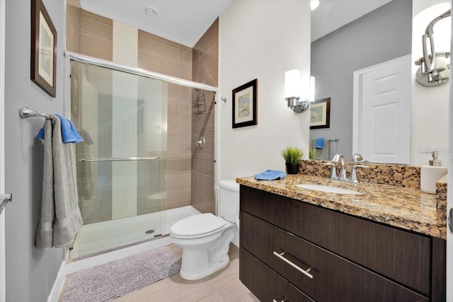 bathroom with vanity, toilet, and an enclosed shower