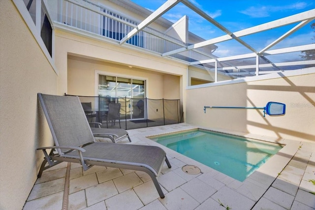 view of pool featuring a jacuzzi, a patio area, and glass enclosure