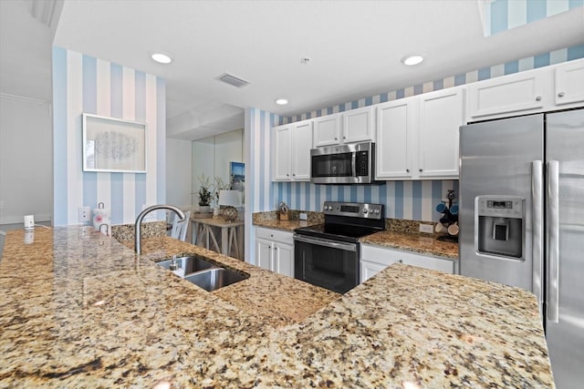 kitchen featuring white cabinets, light stone countertops, sink, and appliances with stainless steel finishes