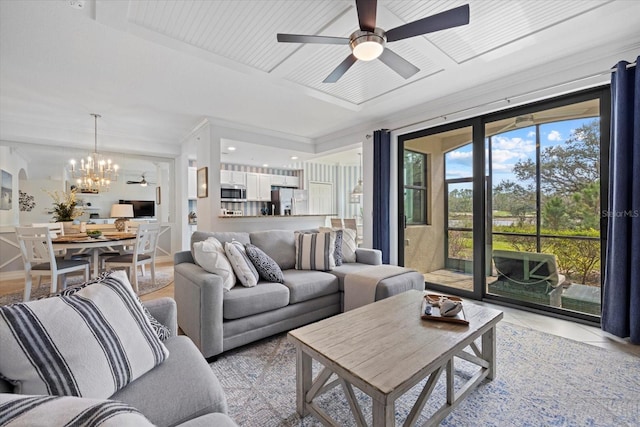 tiled living room featuring ceiling fan with notable chandelier and crown molding