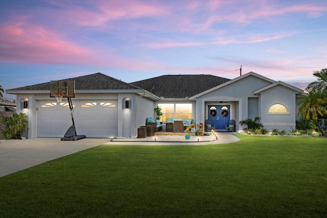 single story home with a garage, concrete driveway, a lawn, and stucco siding