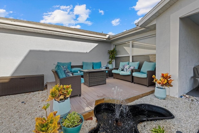 view of patio with an outdoor living space with a fire pit and a deck