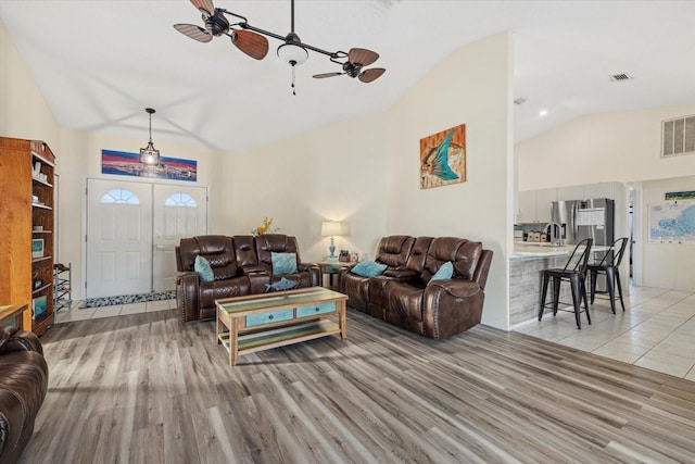 living area with high vaulted ceiling, french doors, visible vents, and light wood-style flooring