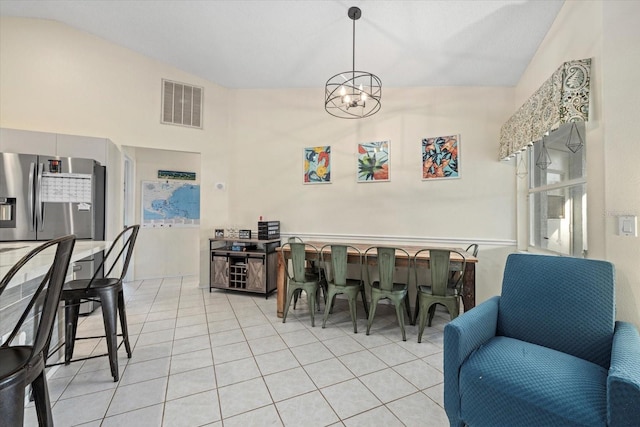 dining space with light tile patterned flooring, lofted ceiling, and an inviting chandelier