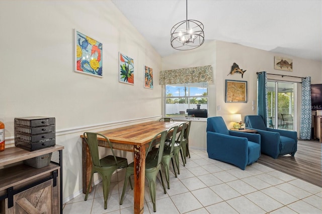 dining area featuring lofted ceiling, a chandelier, light hardwood / wood-style floors, and plenty of natural light