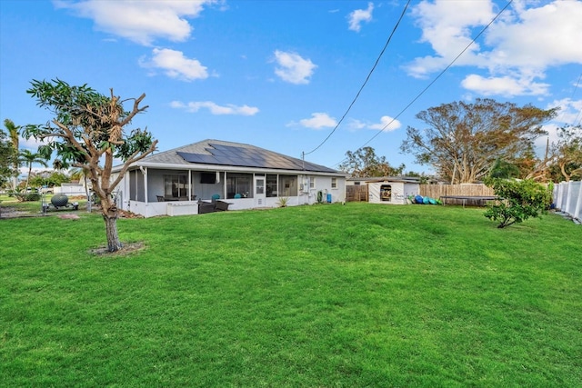 rear view of house with a yard and a sunroom