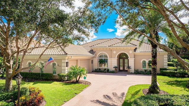 mediterranean / spanish-style house with a front yard and a garage