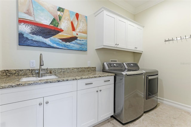 laundry area featuring ornamental molding, cabinets, sink, and independent washer and dryer