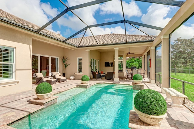 view of swimming pool featuring an outdoor living space, glass enclosure, ceiling fan, and a patio