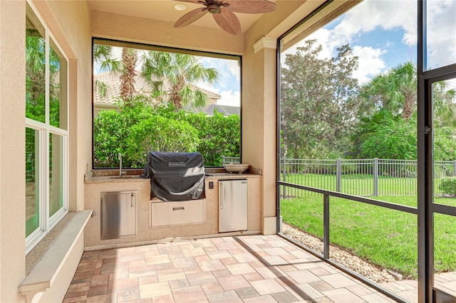 unfurnished sunroom featuring a wealth of natural light and ceiling fan