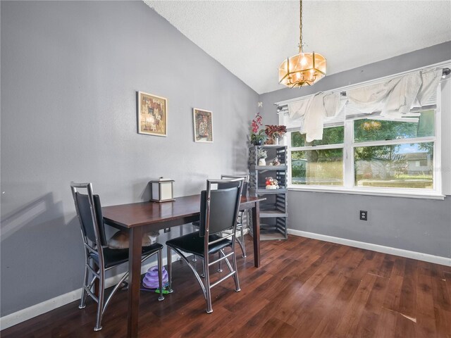 dining space with an inviting chandelier, lofted ceiling, and dark hardwood / wood-style floors