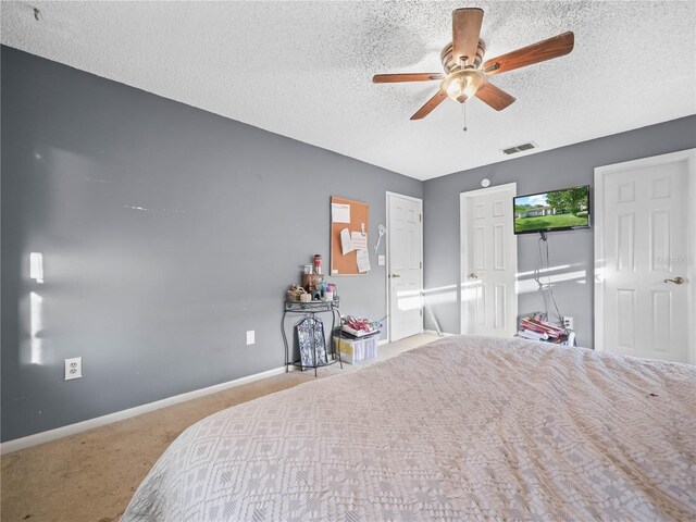 carpeted bedroom featuring ceiling fan and a textured ceiling