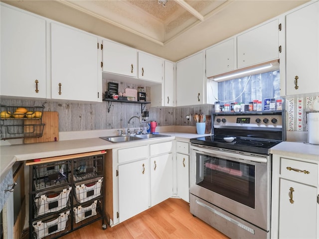 5337 Jacob Ave, Polk City, FL 33868 - kitchen featuring light wood-style flooring, light countertops, stainless steel range with electric stovetop, white cabinets, and a sink