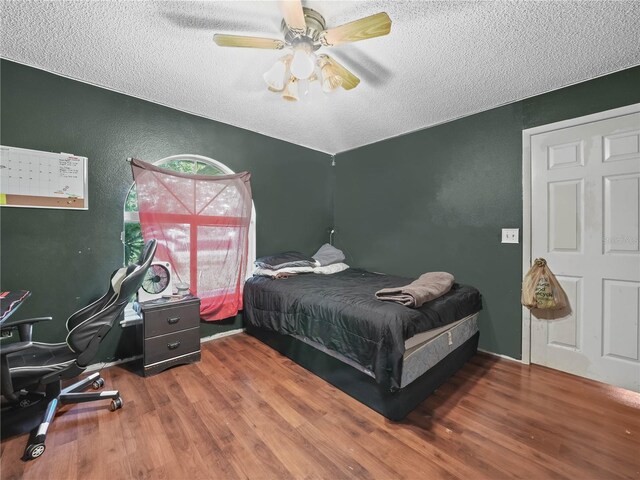 bedroom featuring a textured ceiling, hardwood / wood-style floors, and ceiling fan