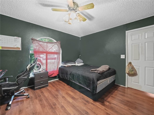 5337 Jacob Ave, Polk City, FL 33868 - bedroom featuring a textured ceiling, wood finished floors, a textured wall, and ceiling fan