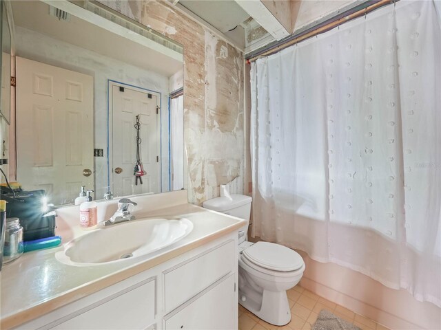 full bathroom featuring shower / bath combo with shower curtain, tile patterned flooring, vanity, and toilet